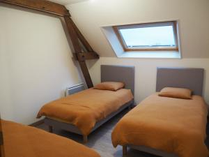 two beds in a room with a window at Le brin d'air Mayennais in Saint-Julien-du-Terroux