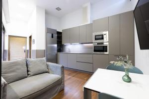 a living room with a couch and a kitchen at Loft 2 by Basquelidays in Hondarribia