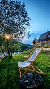 a chair sitting in the grass next to a pool at Riverside Rooms in Šavnik