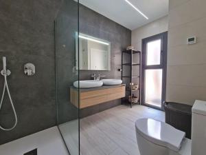 a bathroom with a toilet and a sink and a shower at Hillside Luxury Villas by NRAS in Finestrat +19 photos