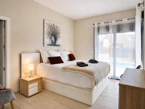 a bedroom with a large bed and a window at Hillside Luxury Villas by NRAS in Finestrat