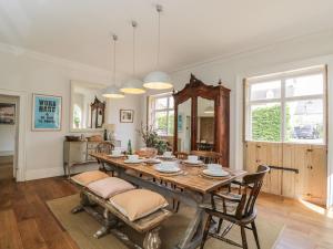 a dining room with a wooden table and chairs at Cotswold House in Moreton in Marsh