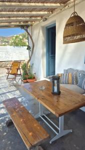 a wooden table on a patio with a couch at Kykladonisia Amorgos in Amorgos