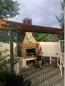 a man standing in front of a brick oven at LouNik stay hotel and rooms in Kobuleti