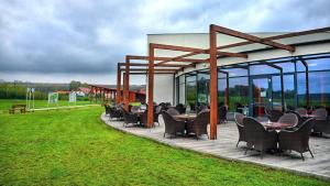 een groep stoelen en tafels op een patio bij Hotel Golf Jezera in Ostrožská Nová Ves