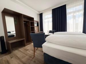 ein Hotelzimmer mit zwei Betten und einem Schreibtisch in der Unterkunft Rabes Hotel Kiel in Kiel