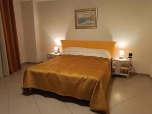 a bedroom with a large bed with two night stands at Aura in Scilla