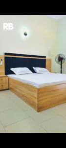 a bedroom with a wooden bed with white sheets at Résidences BHELMAR 