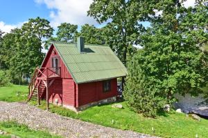 a small red house with a green roof at LAKE VIEW Resort - Sodyba in Skirlėnai