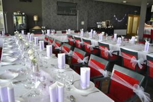 a row of tables with white tablecloths and napkins at Hotel Golf Jezera in Ostrožská Nová Ves