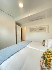 a bedroom with a large white bed in a room at Esmeralda Holidays Apartments in Funchal