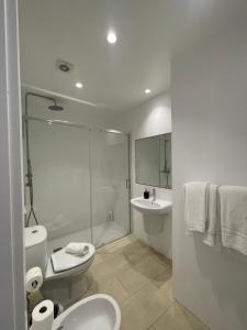 a bathroom with a toilet and a sink and a shower at Esmeralda Holidays Apartments in Funchal +45 photos