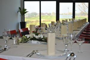 a long table with wine glasses and flowers on it at Hotel Golf Jezera in Ostrožská Nová Ves