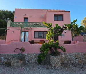 a pink house with trees in front of it at Casa Peregil in Perelló