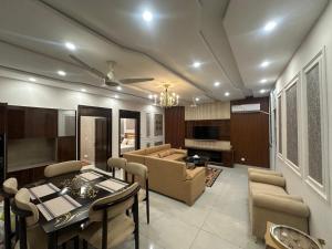 a living room with a couch and a table and chairs at Premium 2 bed room apartment in Lahore