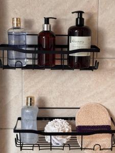 a shelf with three bottles of soap and a towel at The Cloud in Alderley Edge
