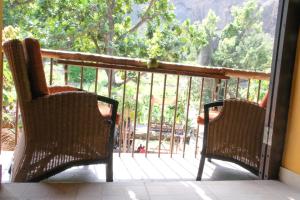 two chairs sitting on a porch with a window at Eco Lodge ZEN GARDEN in Paul +3 photos