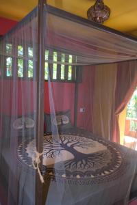 a canopy bed in a room with a window at Eco Lodge ZEN GARDEN in Paul