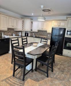 a kitchen with a table and chairs and a black refrigerator at Charming Condo - Pool, Minutes to Beach in Pompano Beach