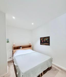 a bedroom with a bed in a white room at L'Ecrin de la Fresque in Beaune