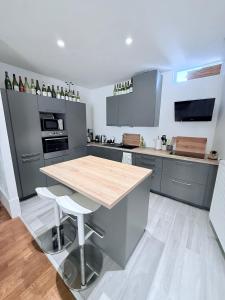 a kitchen with a wooden table and a counter top at L'Ecrin de la Fresque in Beaune