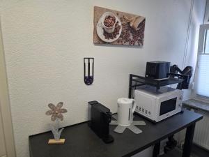 a desk with a microwave and a computer on it at Lisbeth in Sankt Wendel