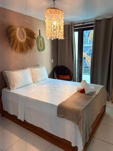 a bedroom with a large bed with a chandelier at Casa Macao Pipa in Pipa +26 photos