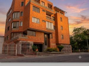 a tall brick building with a sunset in the background at Tu refugio ideal cerca al mar in Playa Bello Horizonte +5 photos