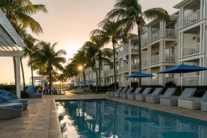 a resort pool with lounge chairs and palm trees at Hilton Key West Resort & Marina in Key West