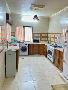 a large kitchen with a stove and a dishwasher at بوابة جرش Jarash Gate in Jerash