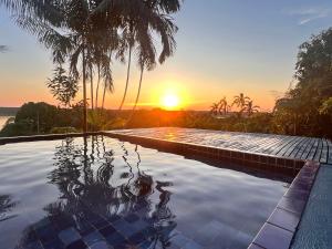a swimming pool with the sunset in the background at Reserva Natural Natura Park in Loreto Mocagua
