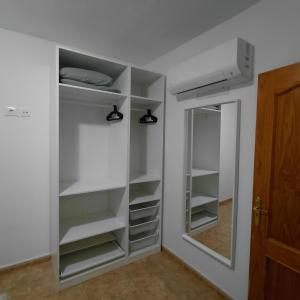 a closet with shelves and a mirror in a room at My Little Bungalow in Palm-Mar