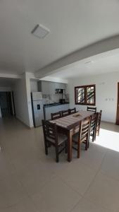 a dining room with a table and chairs and a kitchen at Cabañas Casa Blanca in El Mollar