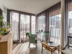a living room with a glass table and some windows at Premium Mountain View Suite in Kirchberg in Tirol