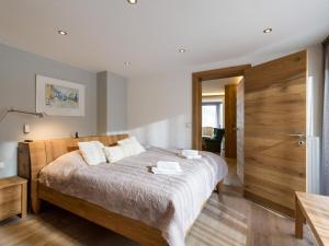 a bedroom with a large bed with a wooden headboard at Premium Mountain View Suite in Kirchberg in Tirol