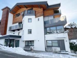 a large white building with snow on the ground at Premium Mountain View Suite in Kirchberg in Tirol