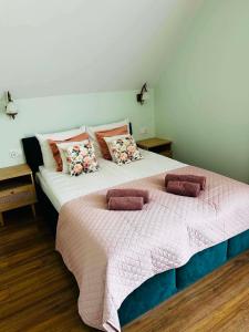 a bedroom with a large bed with two pillows at Pienińska Róża in Szczawnica