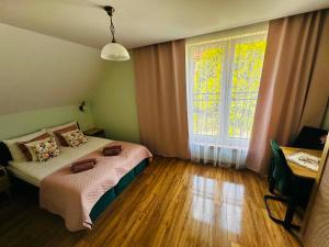 a bedroom with a bed and a large window at Pienińska Róża in Szczawnica