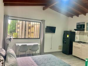 a bedroom with a table and a kitchen with a window at Poblado-Aguacatala Apart-Hotel in Envigado