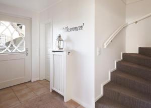 a staircase in a home with a stairway sign on the wall at Haus Amrumblick in Hedehusum