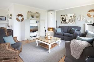 a living room with couches and a coffee table at Haus Amrumblick in Hedehusum