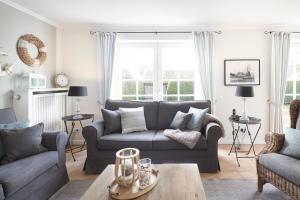 a living room with a couch and a table at Haus Amrumblick in Hedehusum