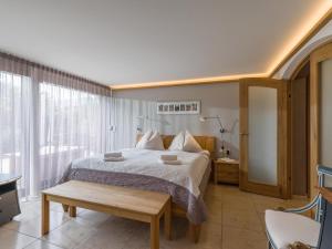 a bedroom with a bed and a large window at Garten Suite mit 2 separaten Studios in Kirchberg in Tirol