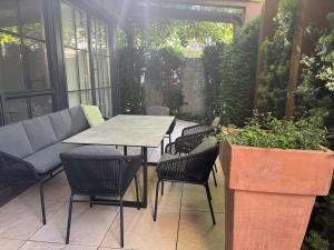 a patio with a table and chairs and plants at Garten Suite mit 2 separaten Studios in Kirchberg in Tirol