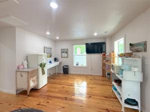 a large room with a refrigerator and wooden floors at -NEW- Spring Wish - Historical Loop Home- in Eureka Springs