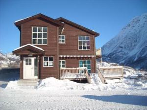 a wooden house with two benches in the snow at Røldal Overnatting in Røldal