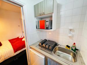 a small kitchen with a sink and a bed at High Tide Hotel in Blackpool