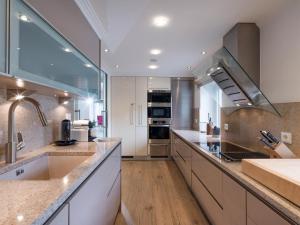 a large kitchen with white cabinets and a sink at Exclusive Garden Suite in Kirchberg in Tirol +11 photos