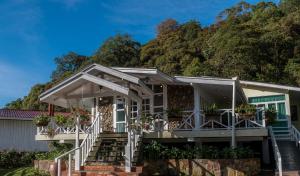 a house with a mountain in the background at Sutera Sanctuary Lodges At Kinabalu Park in Kampong Kundassan