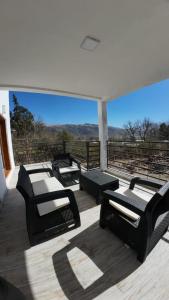 a group of chairs sitting on a deck with a view at Cabañas Casa Blanca in El Mollar